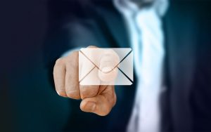 Ein Geschäftsmann der auf einen virtuellen Breifumschlag zeigt um E-Mails zu symbolisieren. Installation von Gpg4win um Ihre Microsoft Outlook E-Mails zu verschlüsseln.